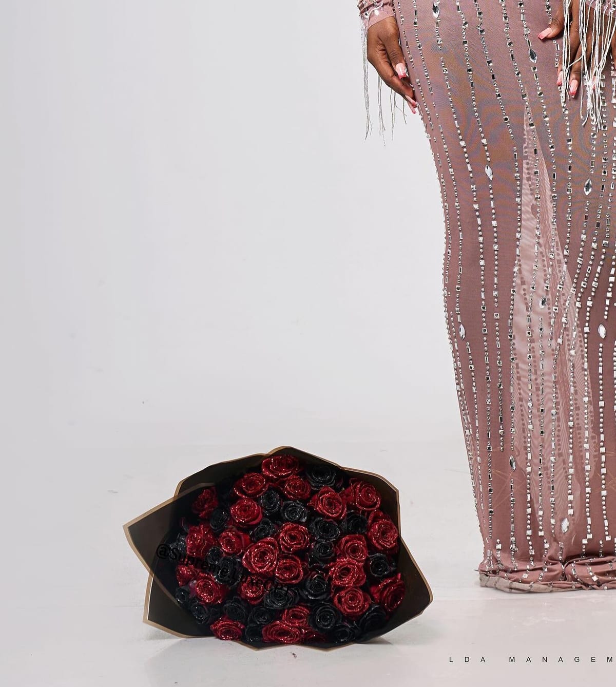 Supreme Luxe bespoke — couture detail beside a red and black glitter rose bouquet